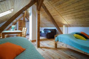 a bedroom with a bed and a couch in a room at Lawki Booking-Na Strychu in Ławki