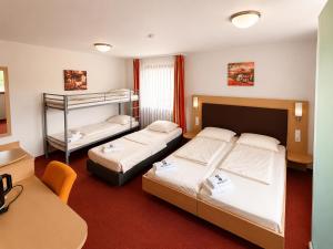 a hotel room with two beds and a desk at Hotel Allee 25 in Stuttgart