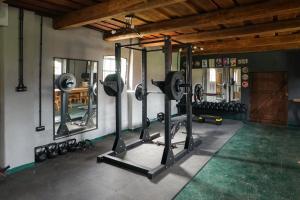 a gym with several treadmills and weights in a room at Lawki Booking-Na Strychu in Ławki