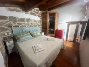 a bedroom with a large bed with a stone wall at Orani Guest House in Orani