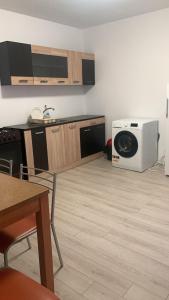 a kitchen with a washing machine and a microwave at Hostel Cazino Sud in Mamaia