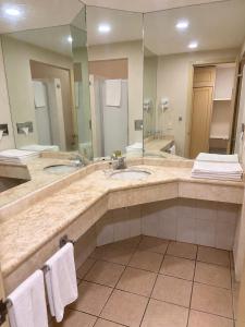 a bathroom with two sinks and a large mirror at Plaza Inn Express in Tapachula