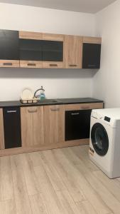 a kitchen with a microwave and a washing machine at Hostel Cazino Sud in Mamaia