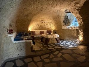 a room with two beds and a table in a cave at Casas Cueva Alfer in Fasnia