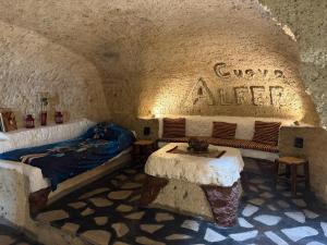 a room with a bed and tables in a cave at Casas Cueva Alfer in Fasnia