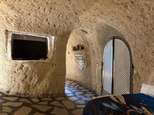 a room with a wall with a door and a tv at Casas Cueva Alfer in Fasnia