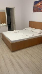 a large bed in a room with a wooden frame at Hostel Cazino Sud in Mamaia
