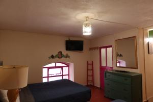 a bedroom with a bed and a dresser and a window at Rinconcito de Galarza 28 in Guanajuato