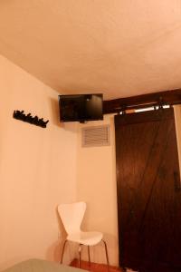 a room with a door and a chair and a television at Rinconcito de Galarza 28 in Guanajuato +33 photos