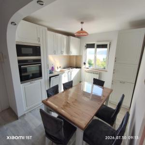a kitchen and dining room with a wooden table and chairs at Apartament -BeaSarah-Orsova in Orşova