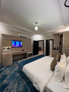 a large bedroom with a large bed and a flat screen tv at The High View Hotel - ذا هاي فيو in Al Baha