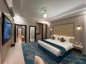 a hotel room with a bed and a flat screen tv at The High View Hotel - ذا هاي فيو in Al Baha +47 photos