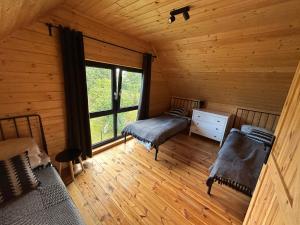an attic room with two beds and a window at Stodoły na Mierzei in Kąty Rybackie