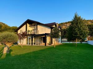 a large house with a green yard with trees at Villa Kadeli 