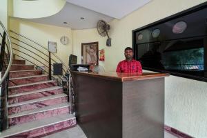 a man standing at a bar with a staircase at Hotel O Pariwar Inn in Hyderabad