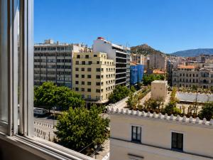 a view of a city from a window of a building at Acropolis Center Rooms in Athens