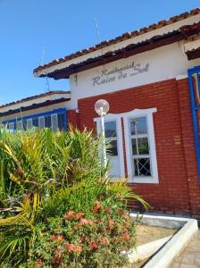 a red brick building with a sign on it at Chalé dos Marques in Caldas Novas