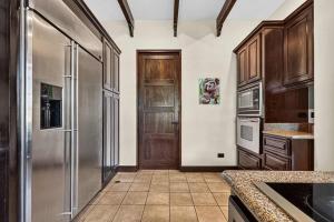 a kitchen with a stainless steel refrigerator and wooden cabinets at Resort Villa Pool Golf & Beach Access in Playa Avellana
