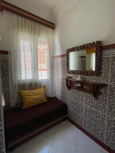 a bedroom with a bed and a mirror on the wall at Casa Amina in Martil