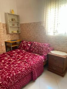a bedroom with a bed with a red bedspread at Casa Amina in Martil