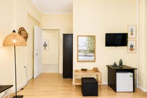 a living room with a table and a tv on the wall at Acropolis Center Rooms in Athens