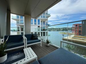 a balcony with chairs and a view of the water at Bryggebyen in Arendal