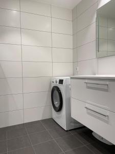 a white laundry room with a washing machine in it at Bryggebyen in Arendal