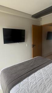 a bedroom with a bed and a flat screen tv at GAV Beach Resort - Smart in Salinópolis
