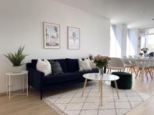 a living room with a blue couch and a table at Bryggebyen in Arendal