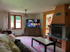 a living room with a couch and a fireplace at Chata Esterka - Oravská Priehrada in Námestovo