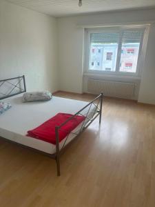 a bedroom with a bed with a red blanket on it at Apartament 2 Zimmer in Grenchen