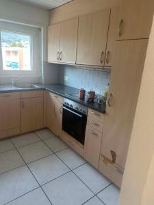 a kitchen with wooden cabinets and a stove top oven at Apartament 2 Zimmer in Grenchen