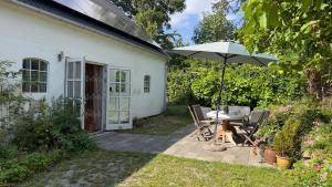a patio with an umbrella and a table and chairs at SommerHuset in Samsø
