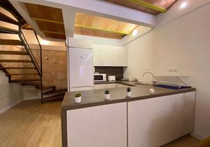 a kitchen with white cabinets and a staircase at Vientos de Tabarca 4 in Tabarca
