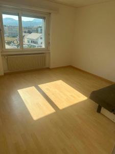 an empty room with a bed and a large window at Apartament 2 Zimmer in Grenchen