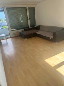 a living room with a couch and a wooden floor at Apartament 2 Zimmer in Grenchen