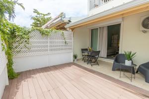 a patio with a fence and chairs and a table at Studio équipé,Terrasse,Marina & plage à pied in Saint-François