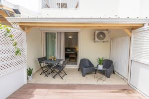 a patio with chairs and a table in a house at Studio équipé,Terrasse,Marina & plage à pied in Saint-François