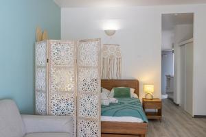 a bedroom with a bed and a wooden partition at Studio équipé,Terrasse,Marina & plage à pied in Saint-François