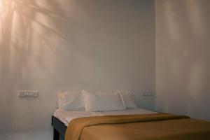 a bed with white sheets and pillows in a room at Jambhul Nest studio Pool & Rainforest Escape in Dhamni