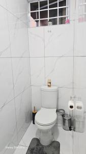 a white bathroom with a toilet and two rolls of toilet paper at HMT Guest House in Thohoyandou +5 photos