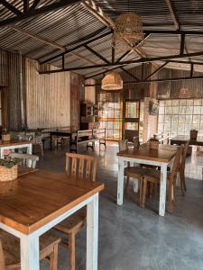 a large room with wooden tables and chairs at Hostería Rural Les Aldudes in San Andrés de Giles