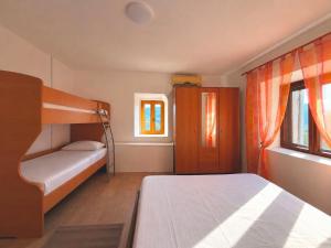 a bedroom with a bunk bed and two windows at Water Lily Dock Prevlaka in Prevlaka