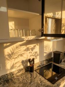 a kitchen counter with a sink with scissors in a cup at Apt Premium com Vista Panorâmica e Lazer Completo in Joinville