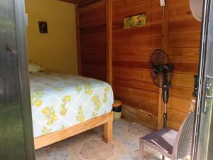 a bedroom with a bed and a wooden wall at Island Breeze in Negril