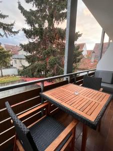 a wooden table and chairs on a balcony at Hotel Allee 25 in Stuttgart