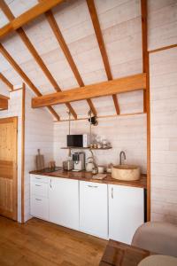 a kitchen with white cabinets and a wooden ceiling at Cabane La Douce Parenthèse - Spa & Sauna in Brive-la-Gaillarde