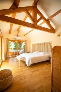 a bedroom with a large white bed and wooden floors at Cabane La Douce Parenthèse - Spa & Sauna in Brive-la-Gaillarde