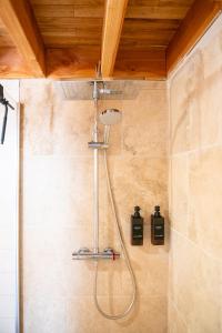 a shower with a shower head in a bathroom at Cabane La Douce Parenthèse - Spa & Sauna in Brive-la-Gaillarde +16 photos