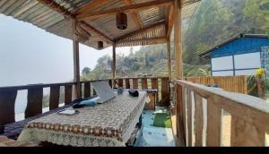a room with a bed with a laptop on a balcony at Prathmesh Homestay in Bijanbāri Bāzār +24 photos